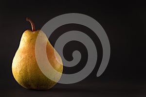 Beautiful ripe yellow pear on black background