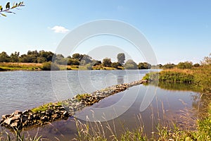 A beautiful river landscape. Flowing river that reflects the sky and plants on the shore