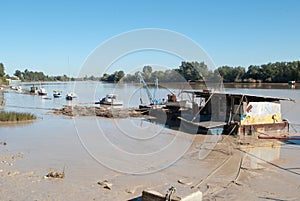 A fluvial workshop covered with mud is surrounded by a flooded river photo