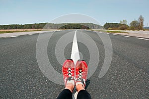 Beautiful road and female legs. Background. Road and field