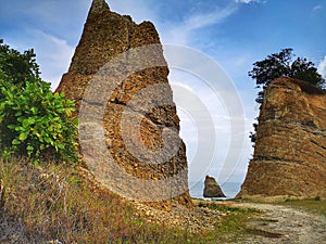 A beautiful rock formation and silky smooth water reflection on beach.