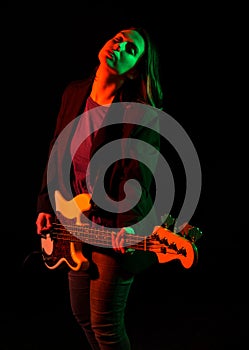 Beautiful rock girl playing bass guitar