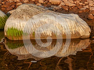 Beautiful rocks by the sea, colorful reflections in the water