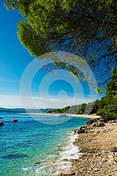 Beautiful rocky beach in Croatia with a view on Zlatni Rat or Golden Cape beach