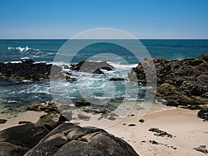 Beautiful rocky sandy beach on sunny day in Portugal