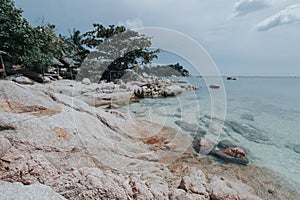 Beautiful rocky shore with white sand with calm waves for tourism campaigns, vacation spots and design needs