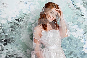 Beautiful and romantic bride in wedding dress with long sleeves. Young redheaded woman in wedding dress