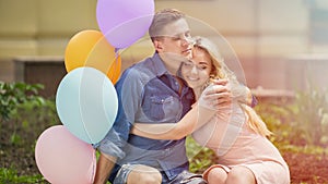 Beautiful romantic couple celebrating anniversary, hugging on bench in park