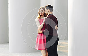 Beautiful romantic couple, woman in a dress and a handsome man are hugging and looking at each other. Valentine`s Day