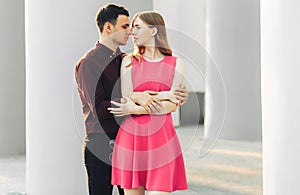 Beautiful romantic couple, woman in a dress and a handsome man are hugging and looking at each other. Valentine`s Day