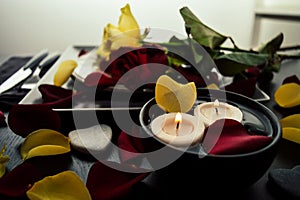 Beautiful romantic dinner with flowers petals, roses, candles. Valentine`s day love night date