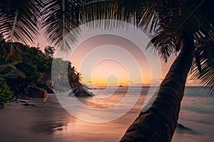 Beautiful romantic sunset sundown colorful sky on Seychelles paradise island. Dream white sand beach and palmtree in the