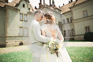 Beautiful romantic wedding couple of newlyweds hugging near old castle