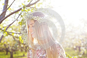 Beautiful romantic woman with long blond hair in a wreath of lily of the valley