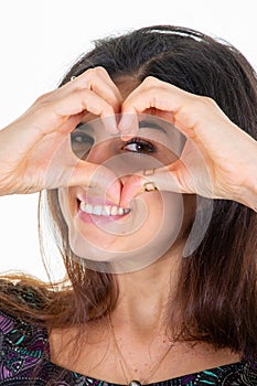 Beautiful romantic woman showing heart hand gesture I love you sign smiling happy on white background