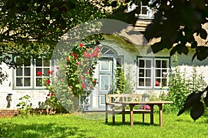 Beautiful and romantical entrance and garden of an old german farmhouse with framework and blooming plants