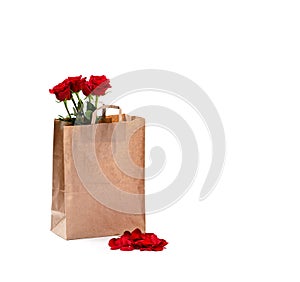 Beautiful roses in paper bag on a light background. Free space for text. Mockup for your design and logo on the package
