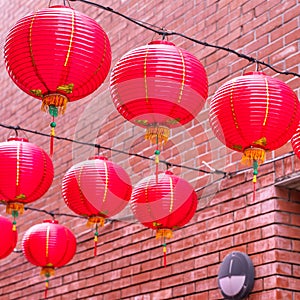 Beautiful round red lantern hanging on old traditional street, concept of Chinese lunar new year festival, close up. The undering