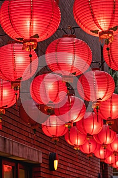 Beautiful round red lantern hanging on old traditional street, concept of Chinese lunar new year festival, close up. The undering