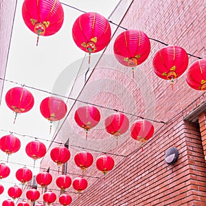 Beautiful round red lantern hanging on old traditional street, concept of Chinese lunar new year festival, close up. The undering