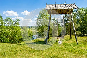 Beautiful rural landscape river Teteriv Teterev. On steep mountain face steeper swing - wooden structure with bench where child