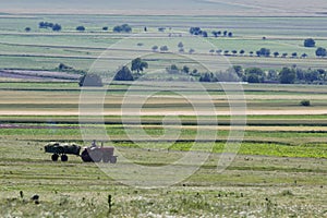 Beautiful rural scene in the spring with a vehicle who gathers fodder