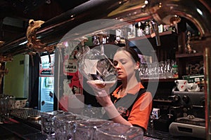 Waitress filling a glass with beer in a bar in Almaty, Kazakhstan