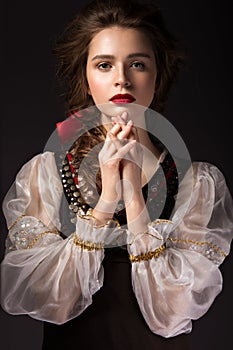 Beautiful Russian girl in national dress with a braid hairstyle and red lips. Beauty face.