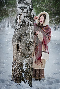 Beautiful Russian woman in a scarf in the winter playing hide an