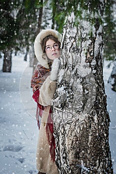 Beautiful Russian woman in a scarf in the winter playing hide an