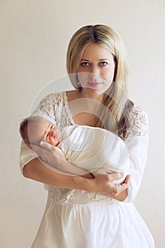 Beautiful Russian woman, a young mother holding a wrapped newbor