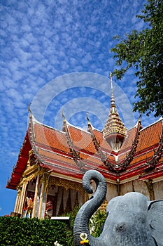 Beautiful sacred red roof and golden spire main hall of famous buddhist temple with blue sky and white cloud background