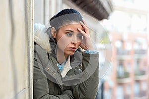 Beautiful sad desperate hispanic woman in winter coat suffering depression