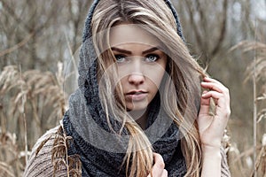 beautiful sad girl is walking in the field. Photo in brown tones.