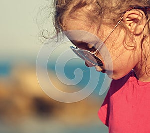 Beautiful sad kid girl profile in fashion trendy sunglasses walk