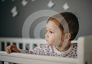 Beautiful, sad little girl indoors portrait in children`s room