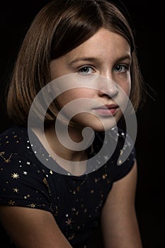 Beautiful sad teen girl, black background