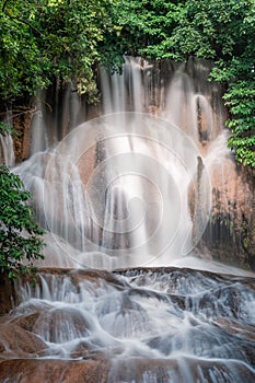 Beautiful Sai Yok Noi waterfall flowing on limestone in tropical rainforest at Kanchanaburi