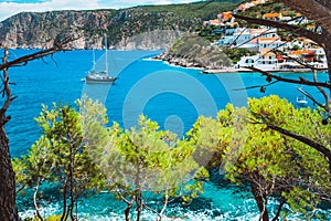 Beautiful sailing yacht near picturesque seacoast. Assos village Mediterranean Sea, Greece. Summer vacation on Greek photo