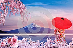 Sakura at Mount Fuji and Kawaguchiko Lake in Japan. A girl wearing a yukata with a red umbrella.