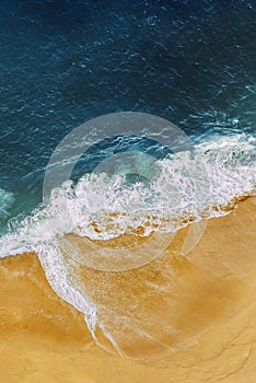 Beautiful sandy beach with blue sea, vertical view. Drone view of tropical blue ocean beach Nusa penida Bali Indonesia.