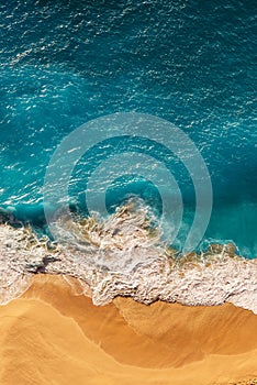 Beautiful sandy beach with blue sea, vertical view. Drone view of tropical blue ocean beach Nusa penida Bali Indonesia.