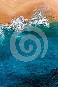 Beautiful sandy beach with blue sea, vertical view. Drone view of tropical blue ocean beach Nusa penida Bali Indonesia.