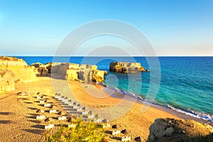 Beautiful sandy beach among rocks and cliffs with sunbeds near Albufeira in Algarve