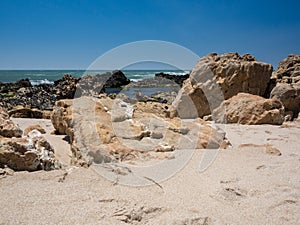 Beautiful sandy beach with sandstone rocks in Portugal in summer
