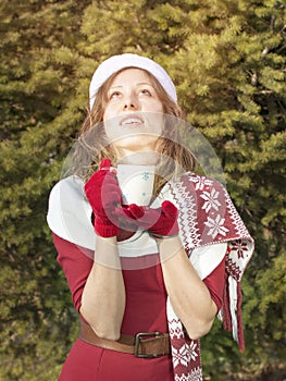 Beautiful Santa Claus girl getting warm with hot beverage