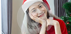 Beautiful Santa Claus woman smile happily,cheerfully and attractive,wearing hat Santa Claus,decorated christmas tree colorful