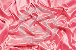 Beautiful satin draped with soft folds fabric, silk cloth background, close-up, copy space