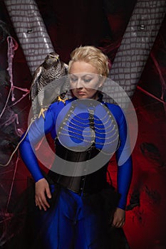 Beautiful scary woman with the big hawk best friend on the background of dark room