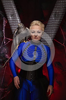 Beautiful scary woman with the big hawk best friend on the background of dark room